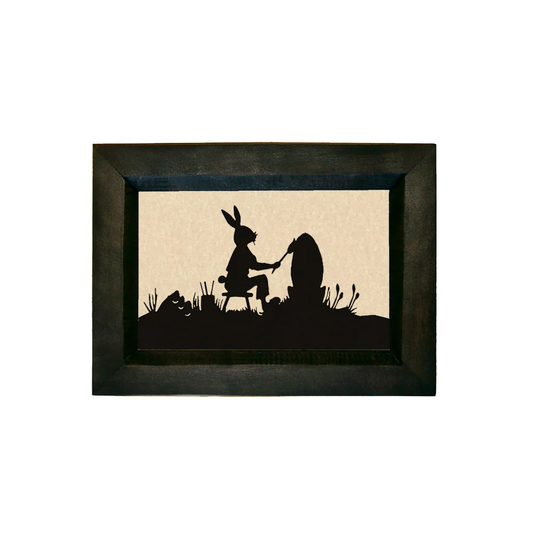 Framed silhouette art of a rabbit and a bear sitting together on a rock.