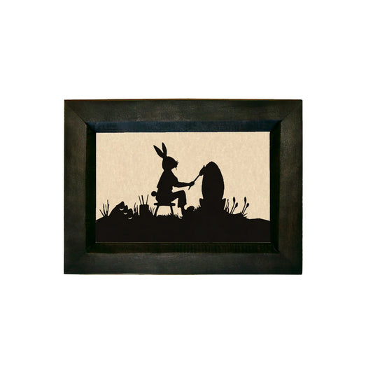 Framed silhouette art of a rabbit and a bear sitting together on a rock.