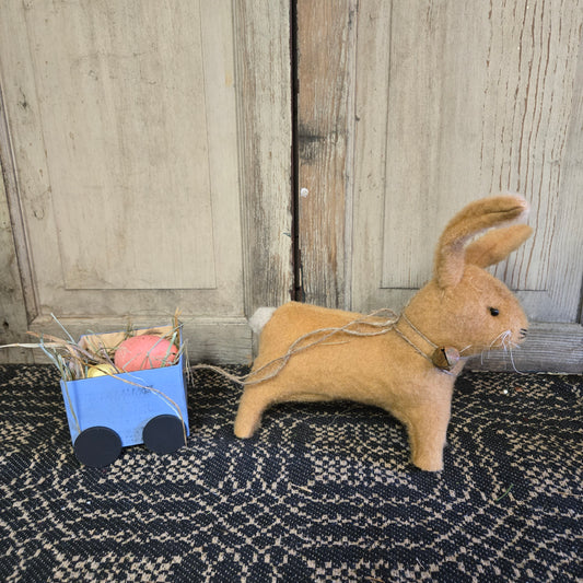 A decorative hand-made blue cart with a cute bunny pulling a load of colorful Easter eggs.