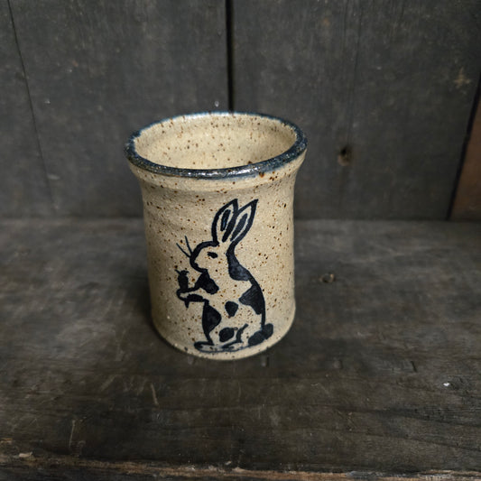 Ceramic cup with a black animal design on a wooden surface