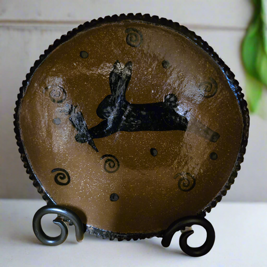 Round stoneware plate with a bunny holding a carrot surrounded by polka dots and squiggles