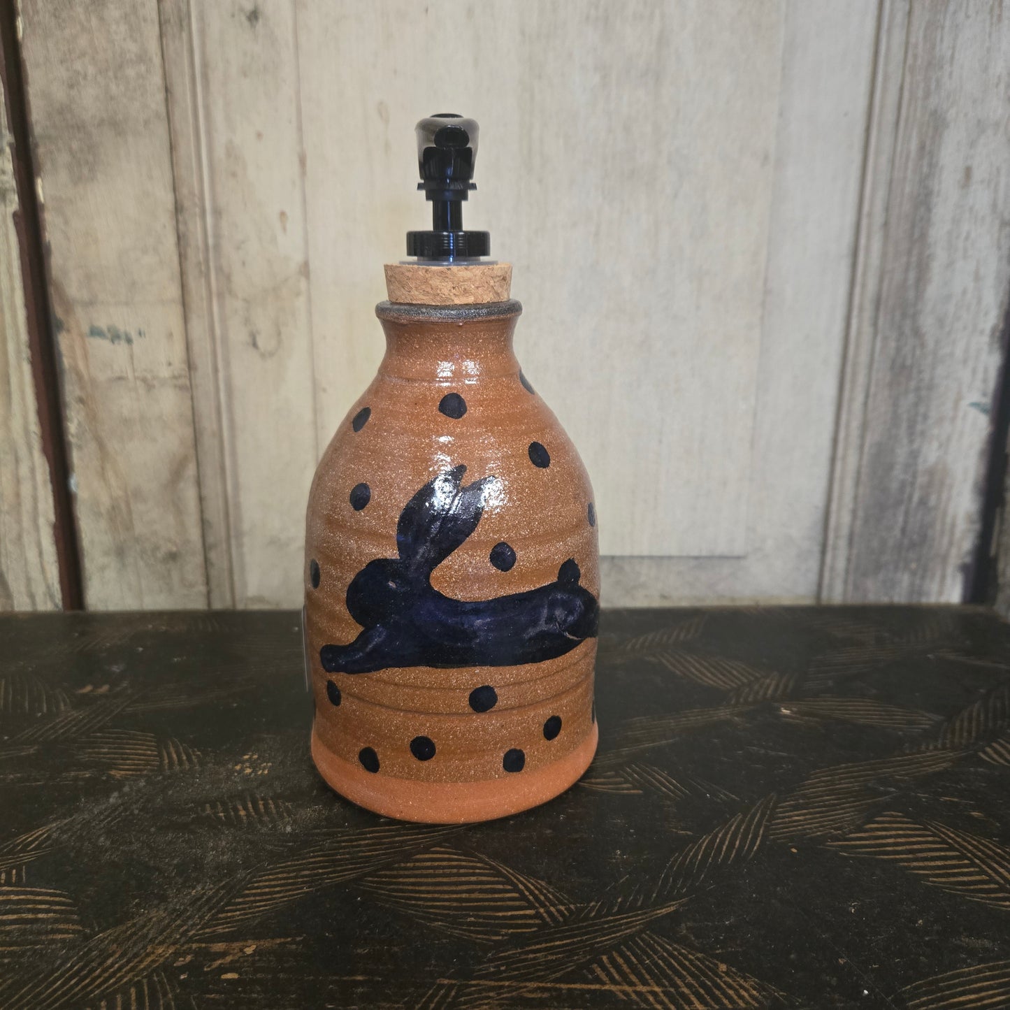 Ceramic bottle with decorative elements on a wooden surface
