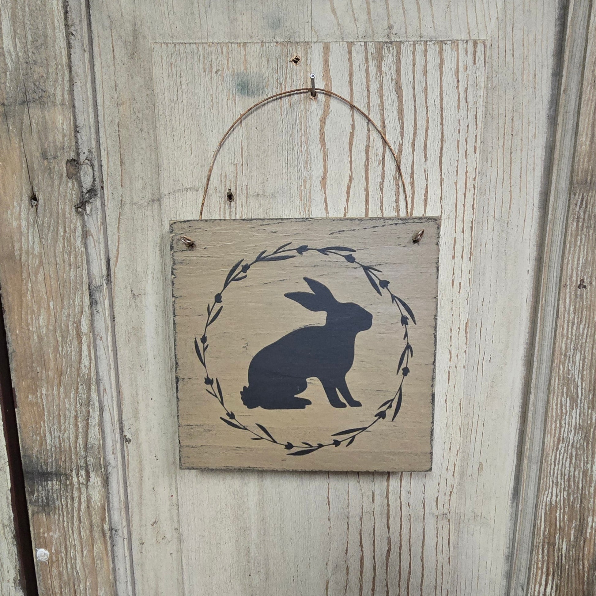 Wooden plaque with rabbit design on a rustic wooden background