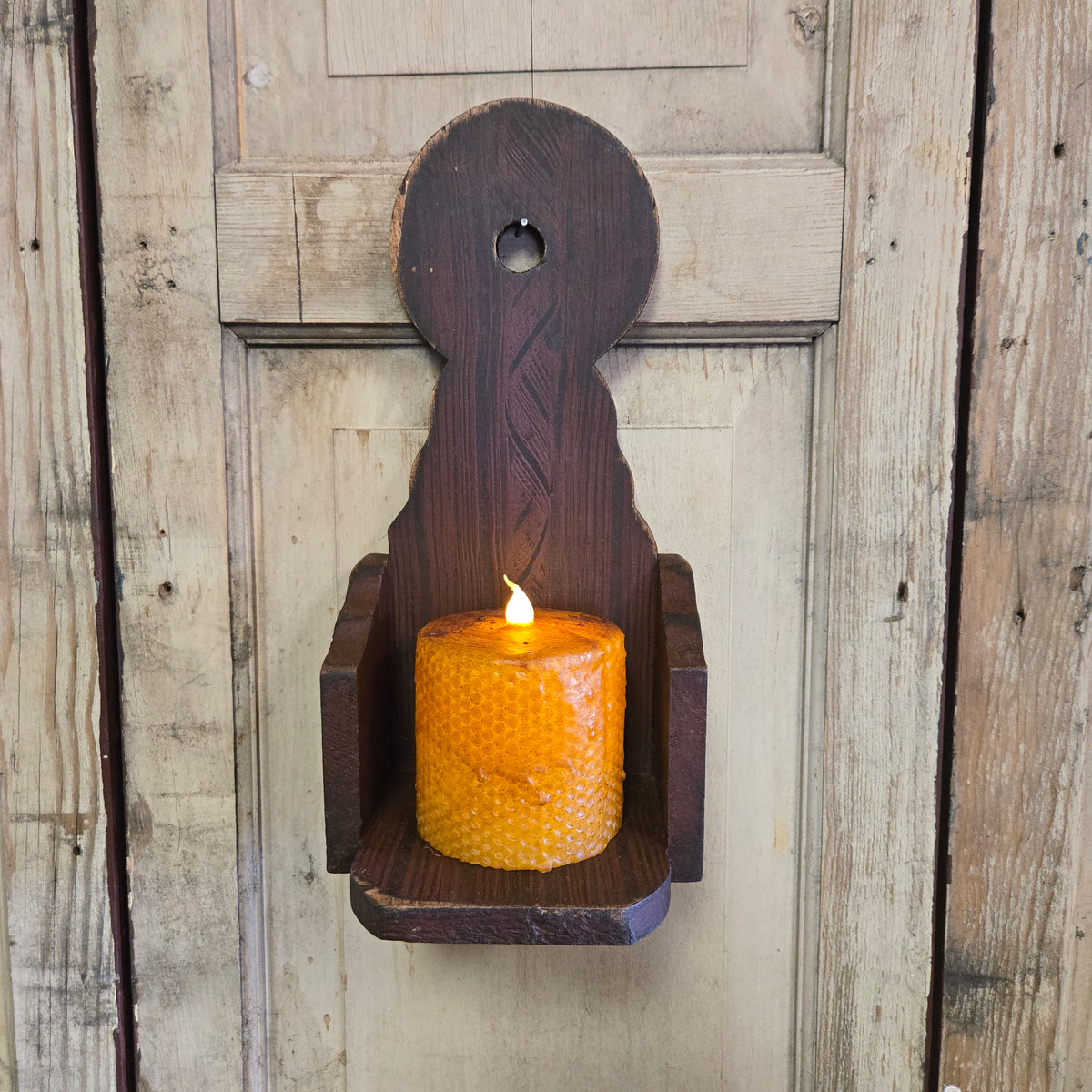 Wood sconce with comb painting on a weathered wood background.