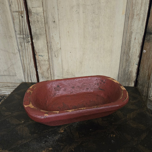 Red wood bowl on a textured surface with wooden planks in the background