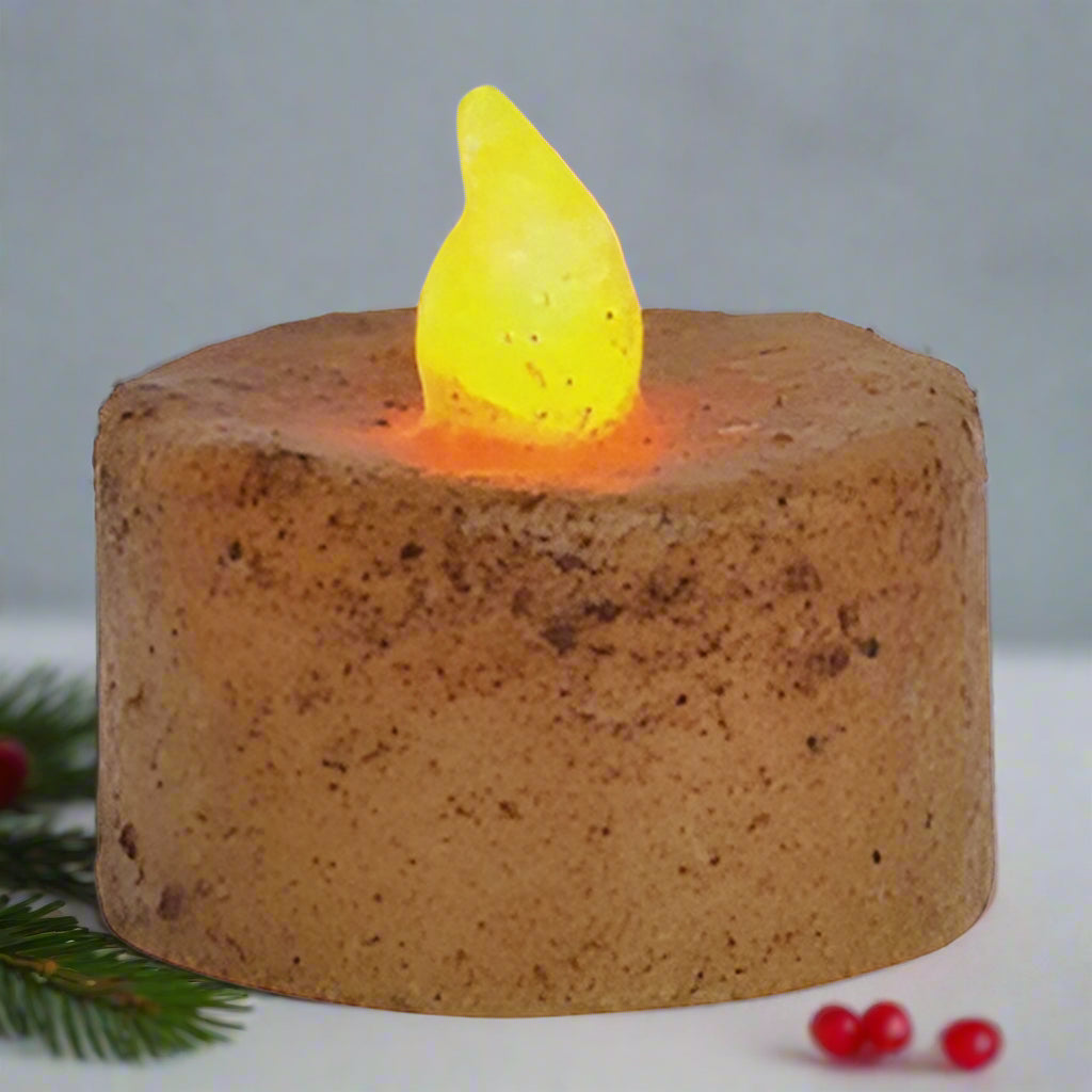Ceramic candle with a glowing yellow flame on a white background
