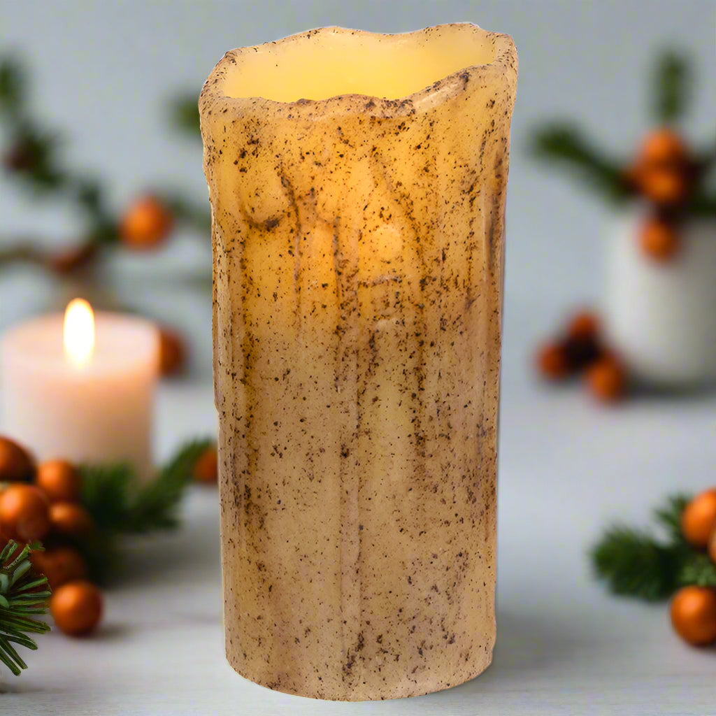 Decorative candle with a textured surface in a festive setting with candles and berries.
