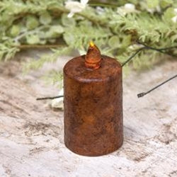 A brown, cylindrical timer pillar with a plastic flame tip on top, placed on a textured surface with a blurred greenery background.