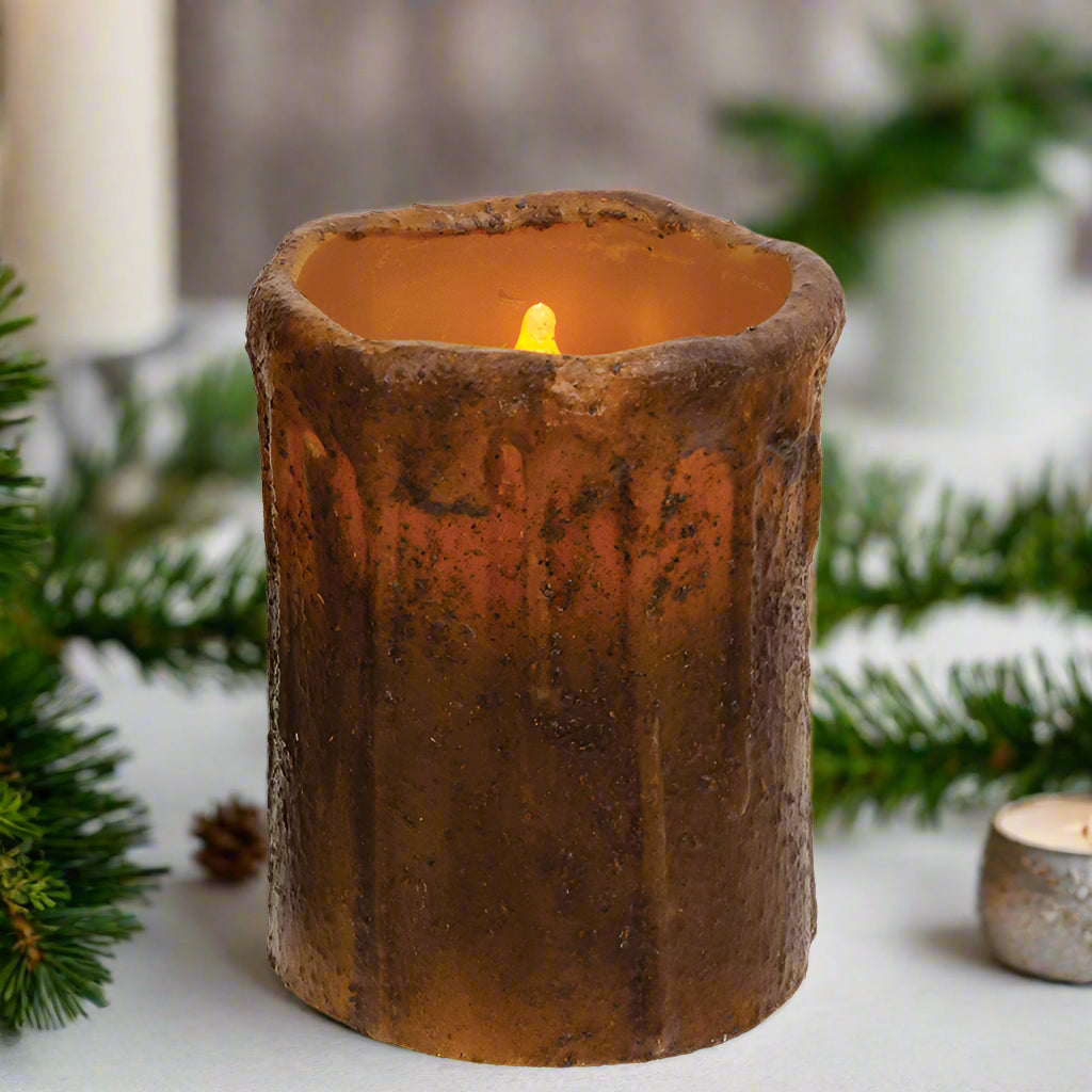 A brown candle with an orange flame, resembling a mustard seed, embedded in a textured brown wax.