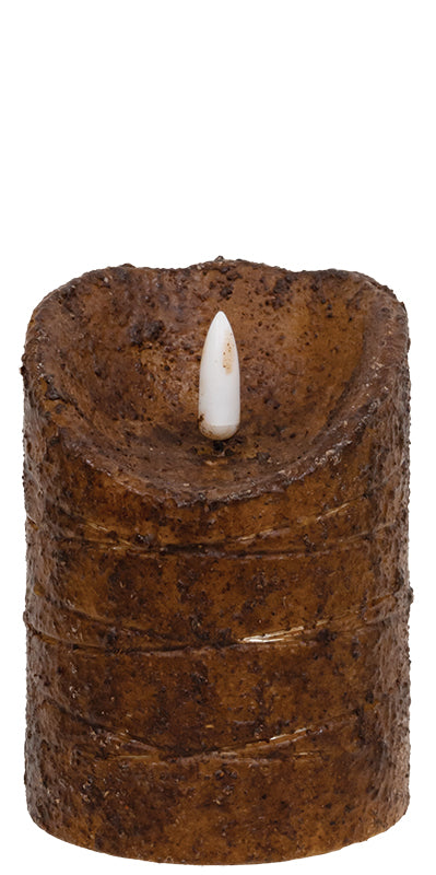 Brown textured candle with a white wick on a white background