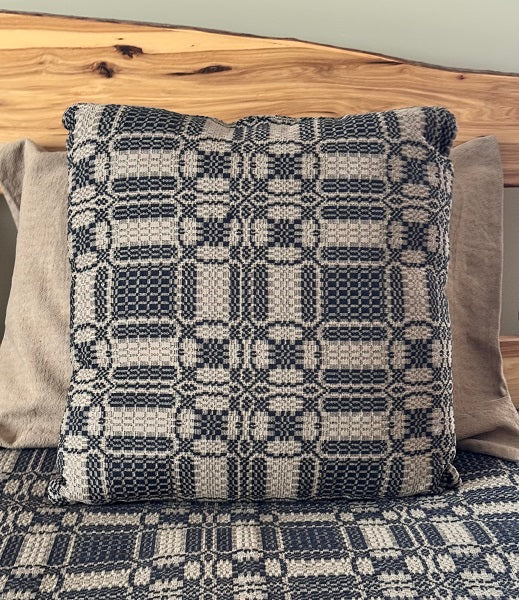 Patterned pillow on a bed with wooden headboard