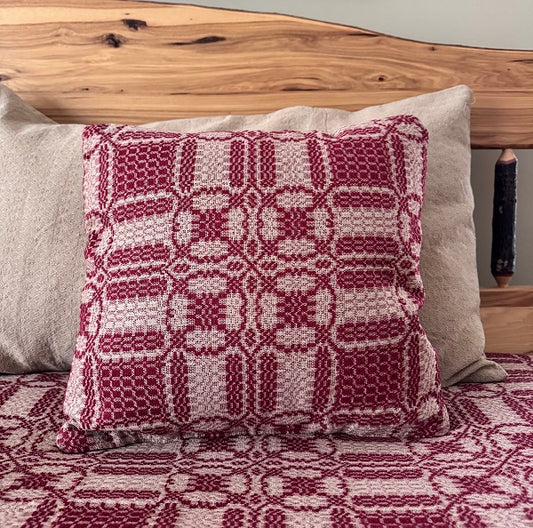 Patterned pillow on a bed with wooden headboard