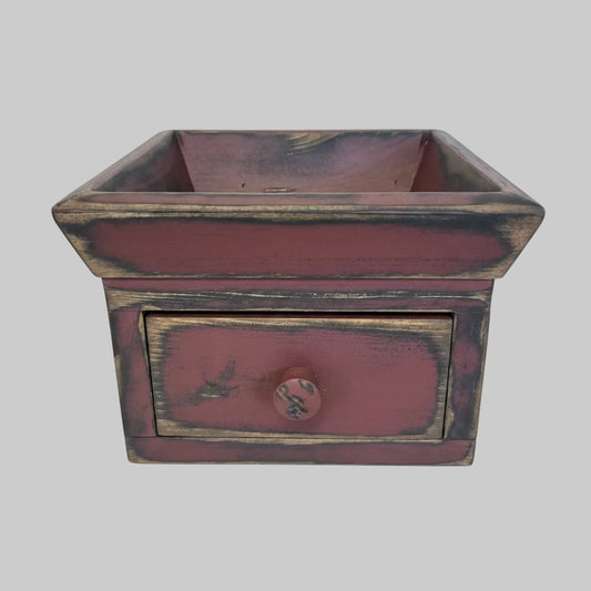 A small rustic wooden box with a single drawer and a square open top, painted in a distressed reddish-brown finish with dark weathered edges and a round knob on the front.
