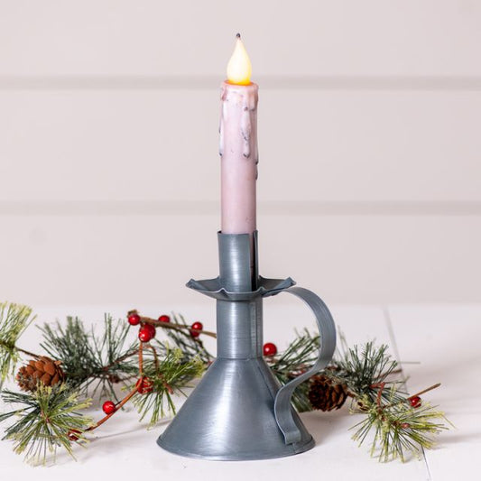 Tin candleholder that accommodates a real or battery operated taper with greenery