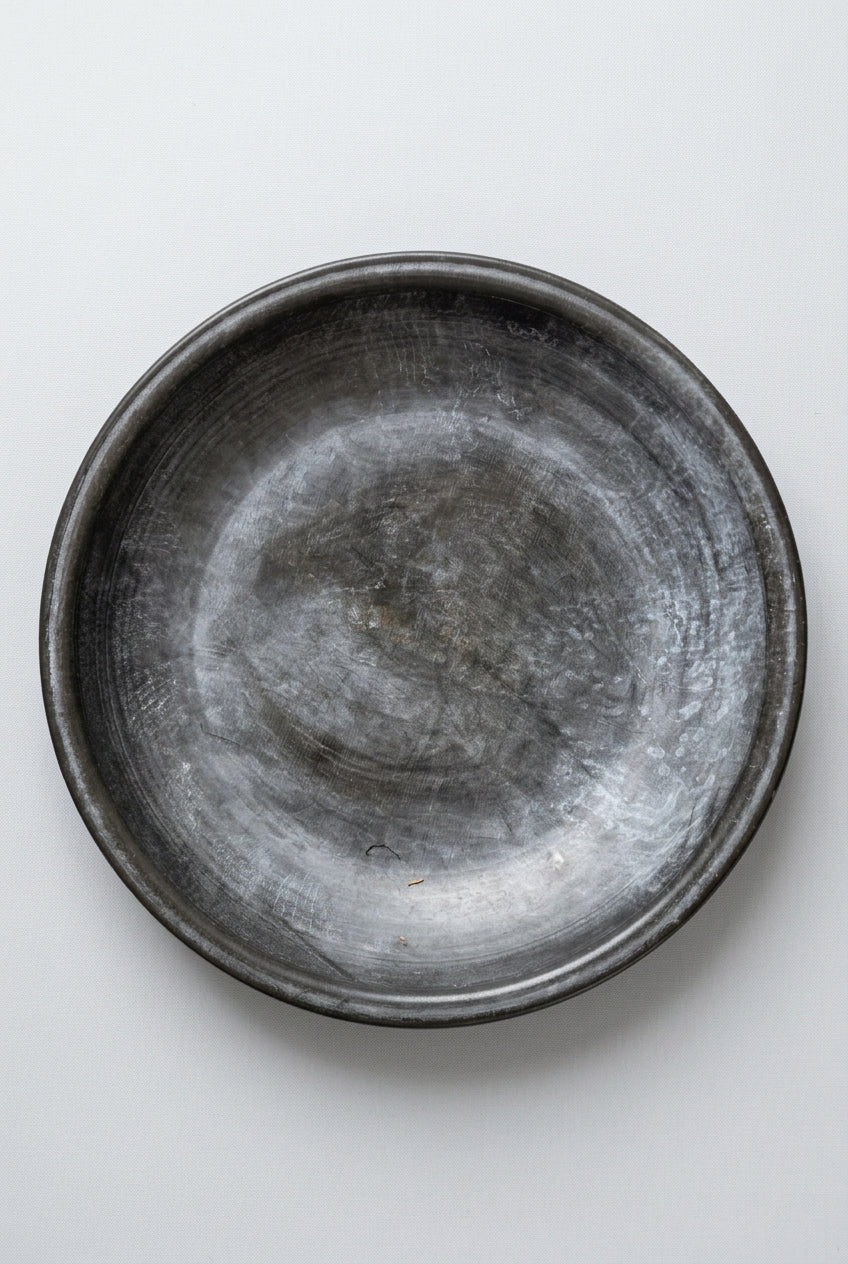 Metallic bowl on a textured black and beige surface