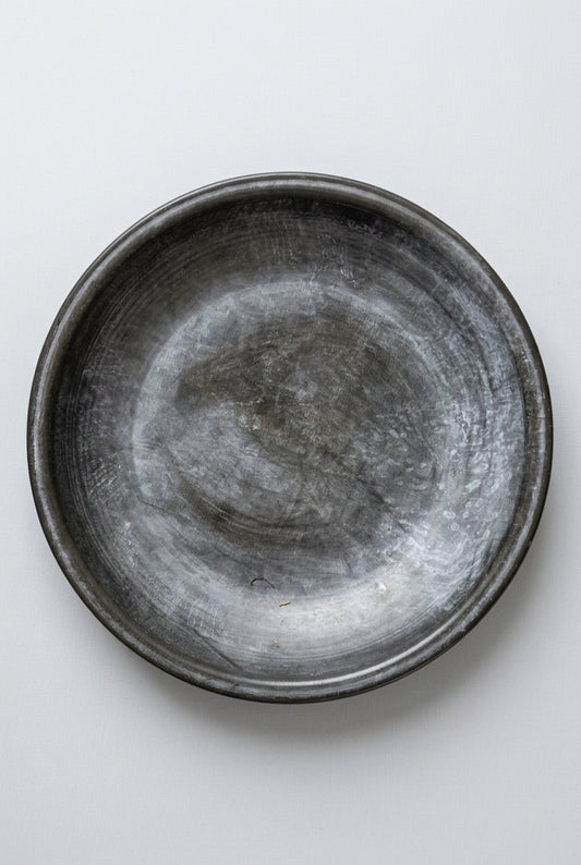 Metallic bowl on a textured black and beige surface