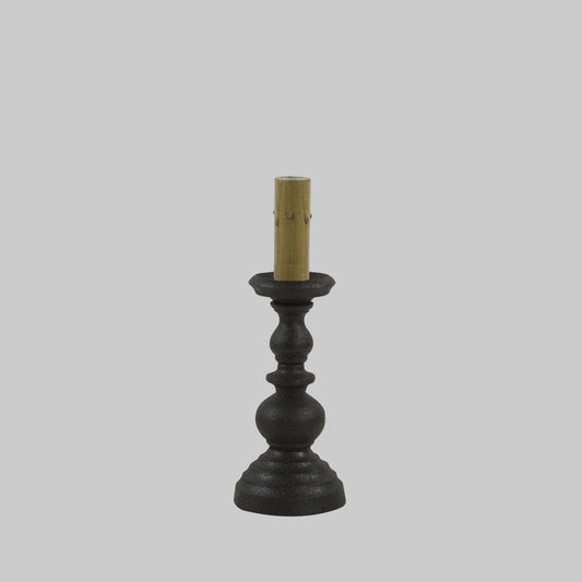 Black candlestick holder with a gold candle on a white background