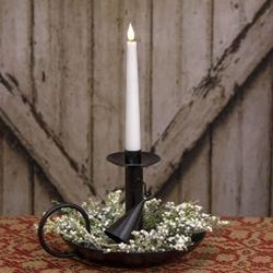 Candle in a decorative holder with flowers on a wooden surface