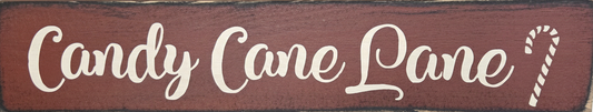 Wooden sign with 'Candy Cane Lane' text on a red background
