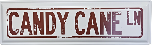Street sign with 'CANDY CANE LN' text on a white metal background