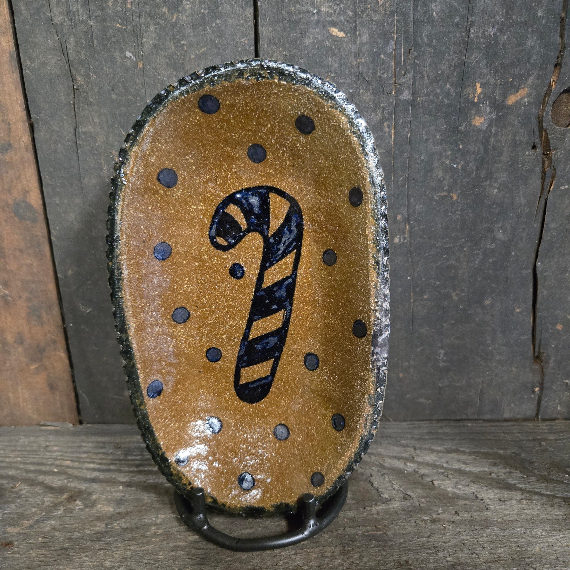 Oval stoneware plate with candy cane design.