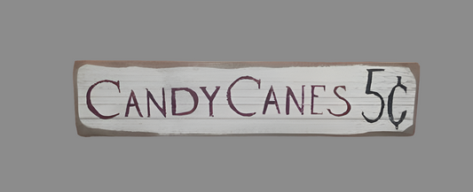 A wooden sign with the text 'Candy Canes 5 Cents' written in a rustic style.