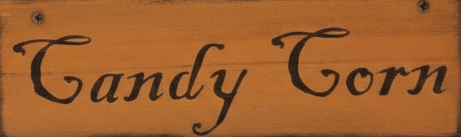 Wooden sign with 'Candy Corn' text on a wooden background