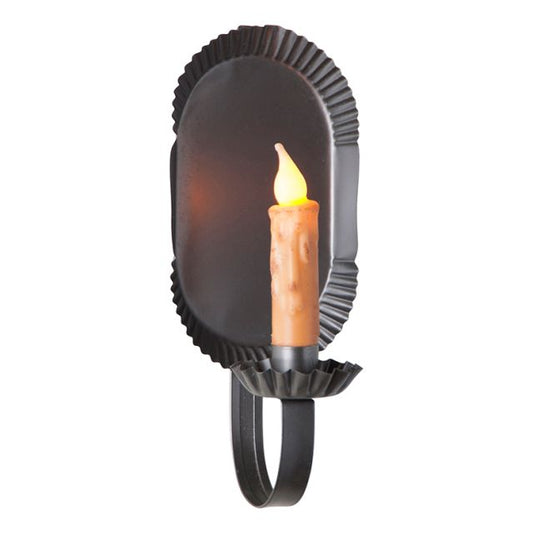 A black metal candle sconce with a smokey finish, designed to hold a candle. The sconce is shaped like a rounded tin with a handle at the bottom.