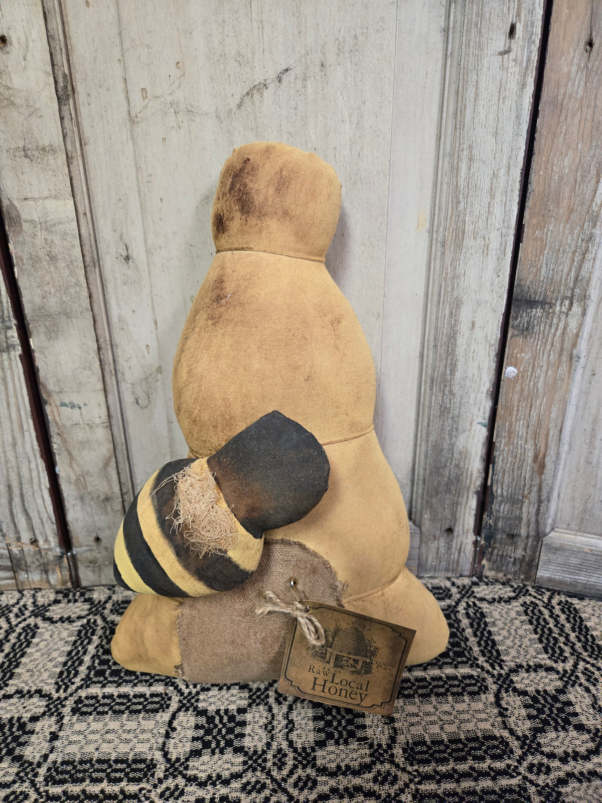 Decorative honey bear with a tag on a wooden background
