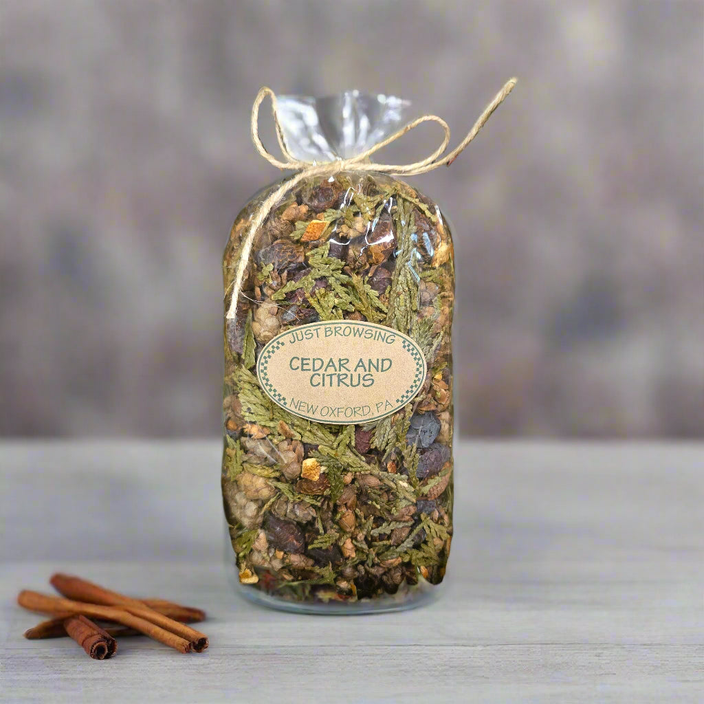 Herbal product labeled 'Cedar and Citrus' on a bed of green leaves