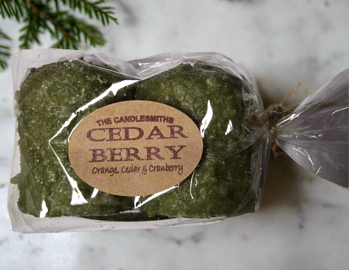 A pack of two green candles tied with a label that reads 'The Candlesmiths Cedar Berry'.