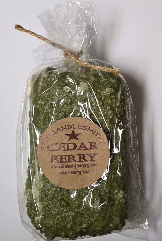 A Cedar Berry scented candle by Candlesmith, wrapped in wax paper and secured with a string, with a label that reads 'Cedar Berry' and the brand 'Candlesmith'.