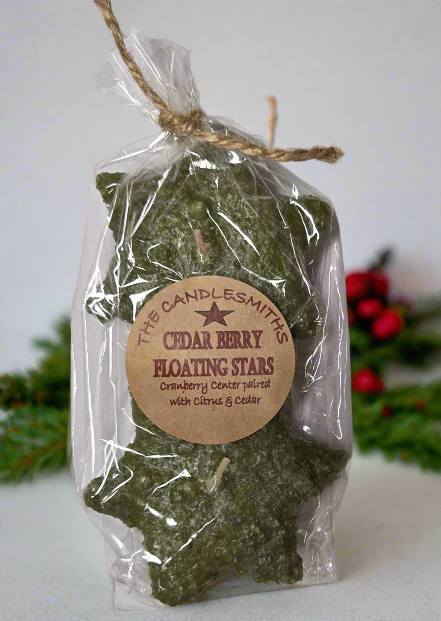 Two small star-shaped floating candles with a green tint, packaged in a clear plastic bag tied with twine at the top.
