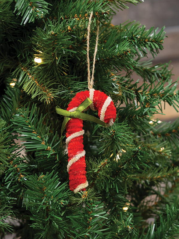Red candy cane ornament hanging on a Christmas tree
