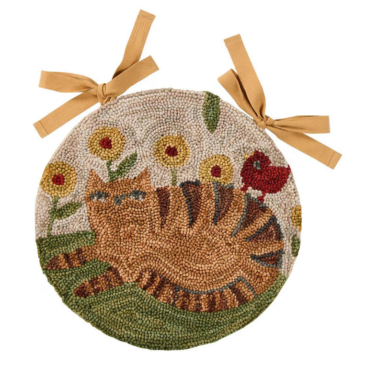 Round woven mat with a cat and flowers design, tied with ribbons on a white background