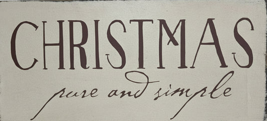 Decorative sign with 'Christmas pure and simple' text on a wooden background