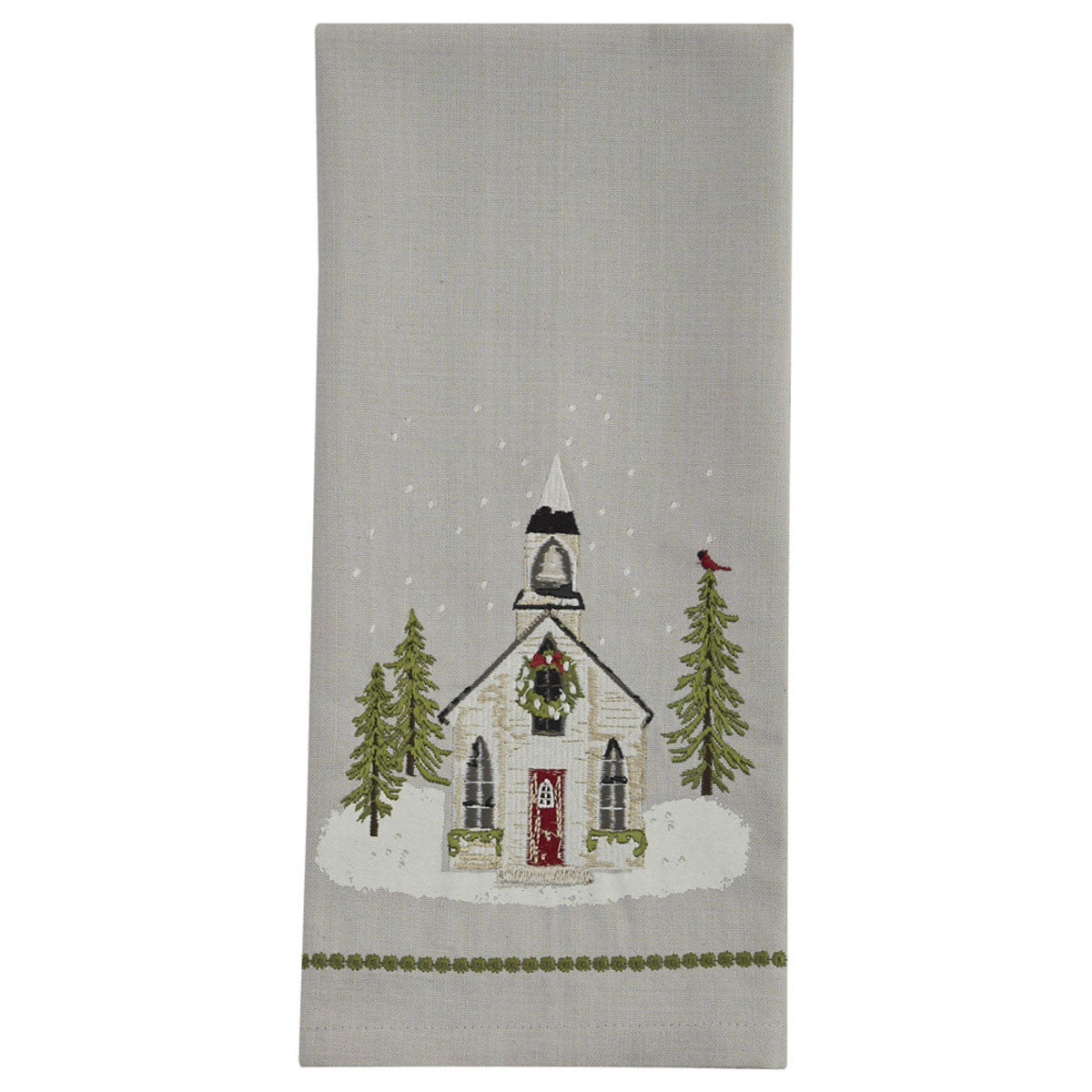 A Christmas-themed dishtowel featuring a church design with snow on the ground, trees, and a bird.