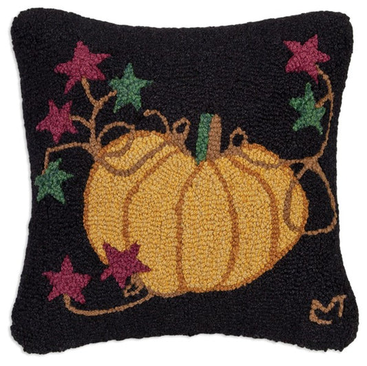 A rectangular hooked wool pillow with a black background featuring a hand-hooked design of a pumpkin and stars.
