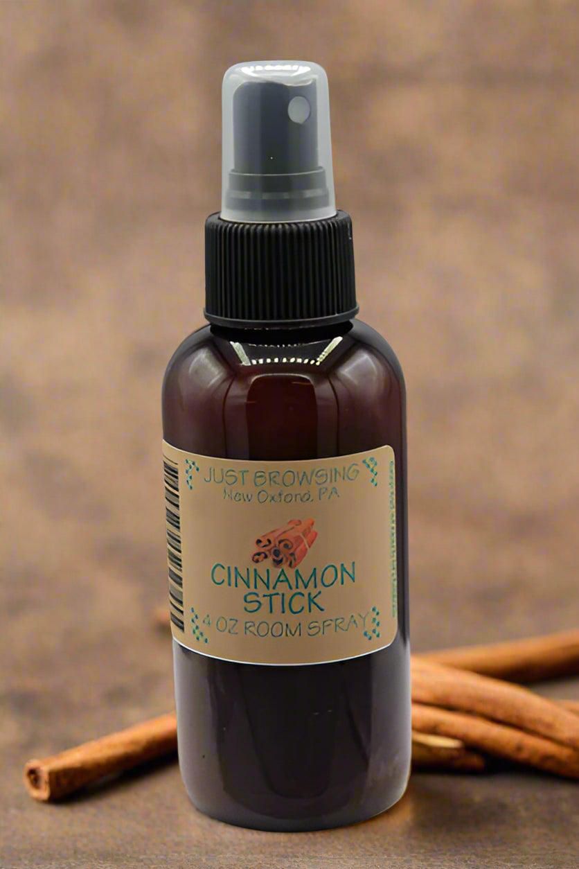 Brown spray bottle labeled 'Cinnamon Stick' on a gray background with cinnamon sticks