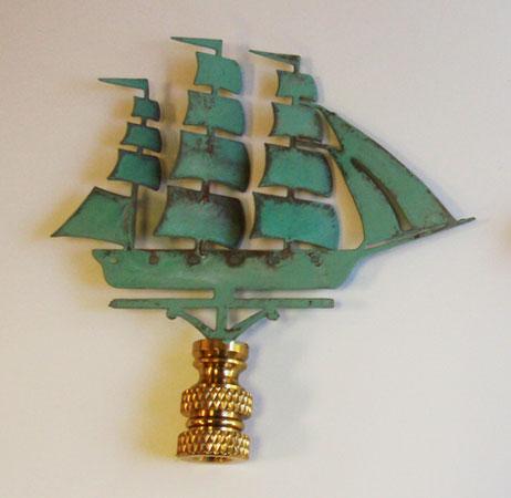 A copper lamp finial with a verdigris finish, designed in the shape of a sailing ship.