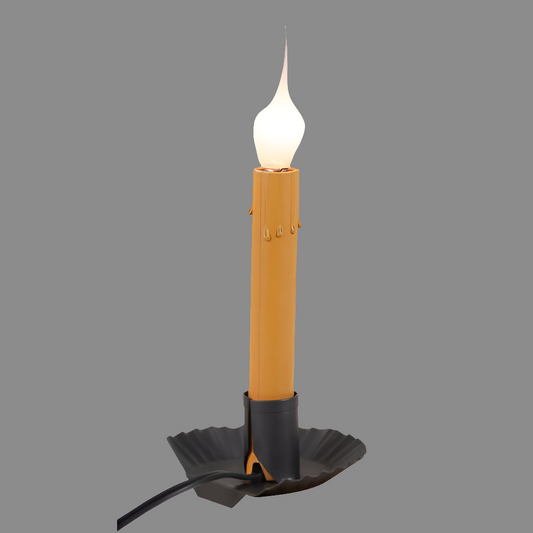 A smokey black window sill light with a yellow candle-like appearance, with a wire base and a switch on the cord.