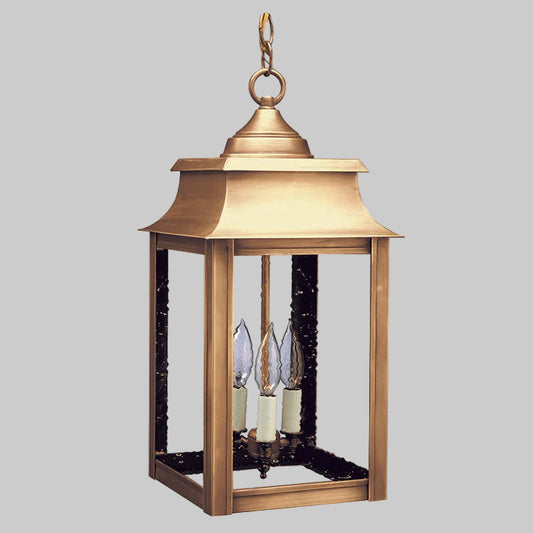 Brass outdoor lantern with three candle-like lights on a white background