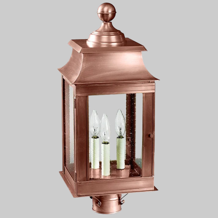 Copper outdoor lantern with three candle-like lights on a white background