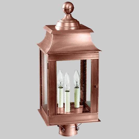 Copper outdoor lantern with three candle-like lights on a white background