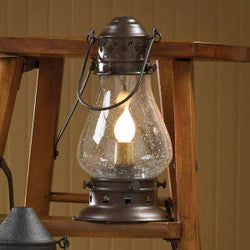 Vintage-style lantern with a lit bulb inside, placed on a wooden surface.