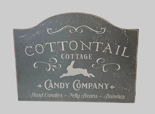 Decorative sign for Cottontail Cottage Candy Company with rabbit illustration on a gray background