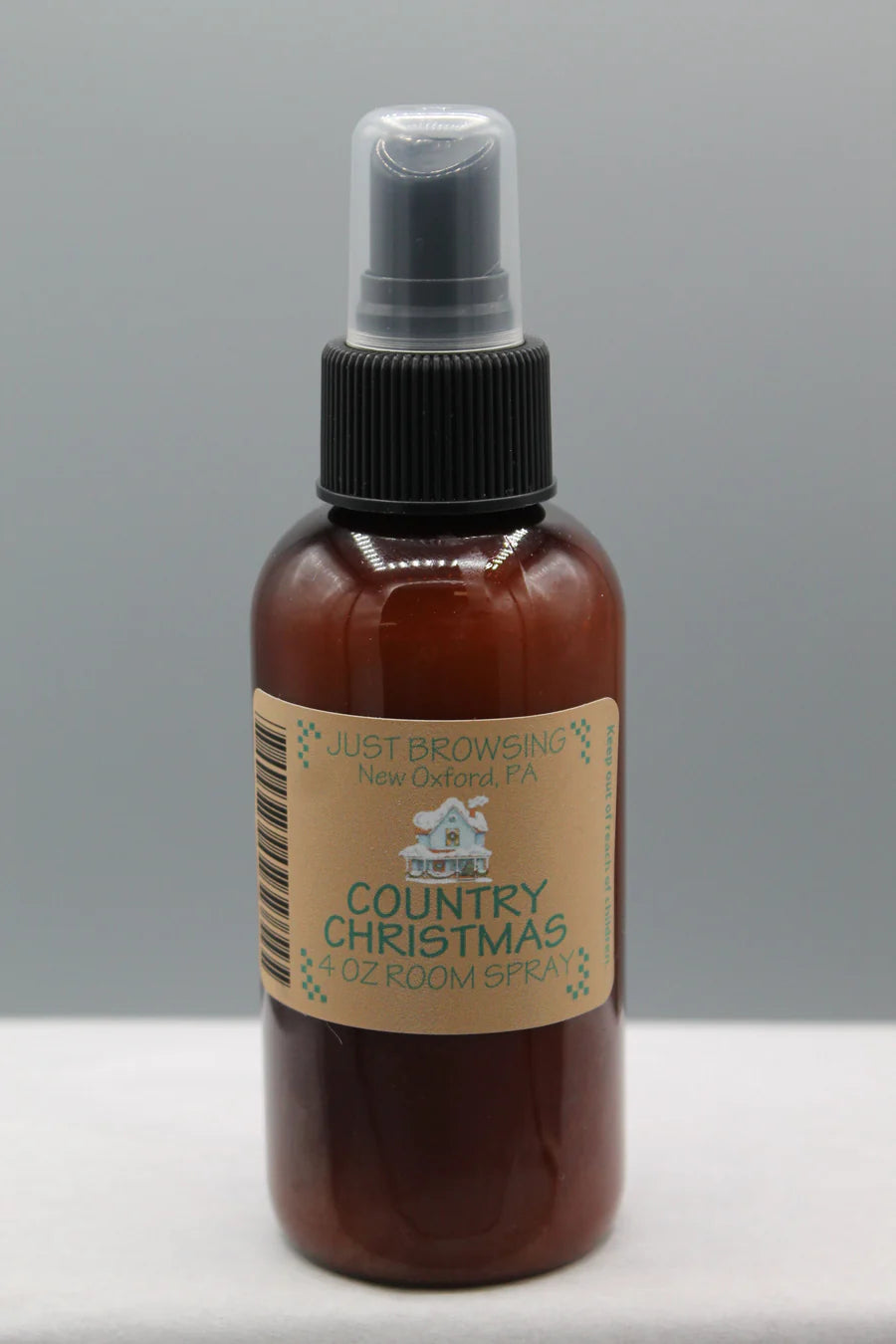 A 4oz bottle of Country Christmas room spray with a mist spray top. The bottle is brown with a label that includes the product name and a Christmas tree graphic.