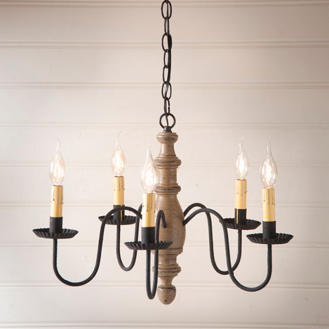 Wooden chandelier with five candle-style lights on a neutral background