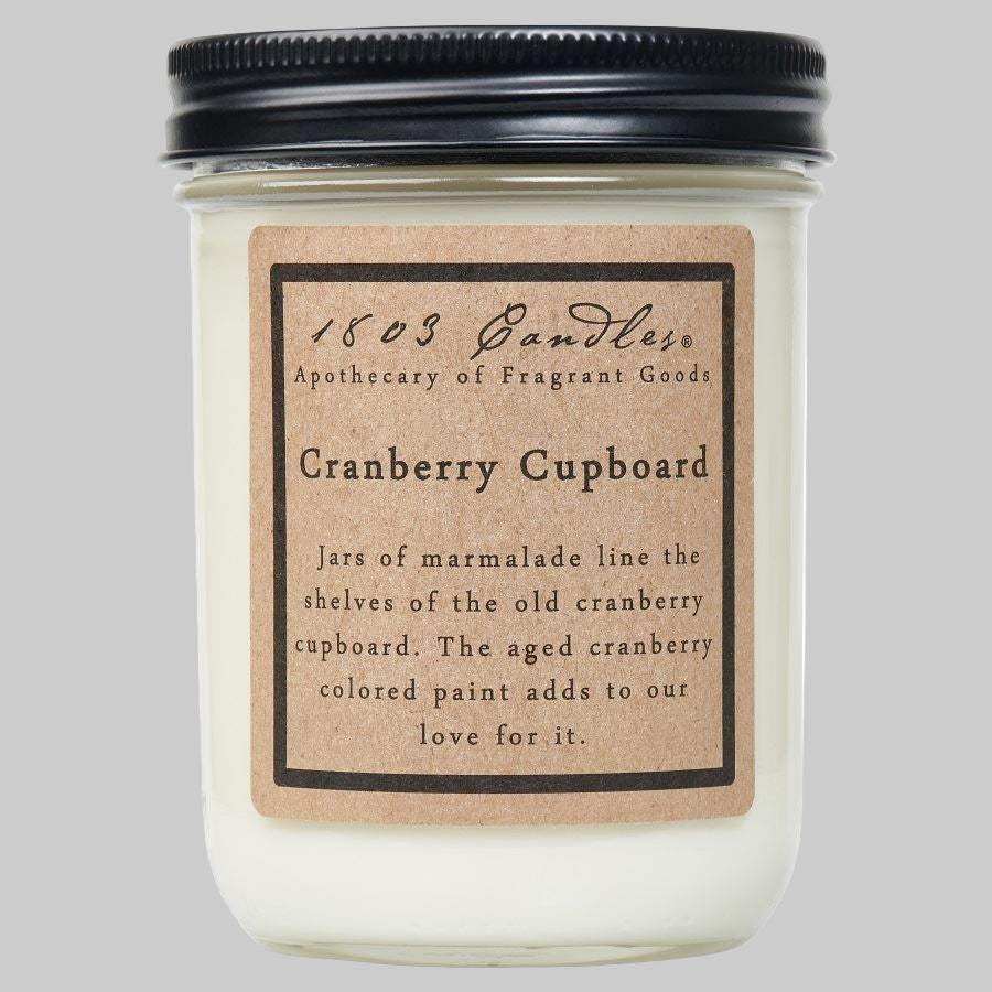 A 14oz jar of 'Cranberry Cupboard' candle with a label that includes the product name and the brand 1803 Glass House.