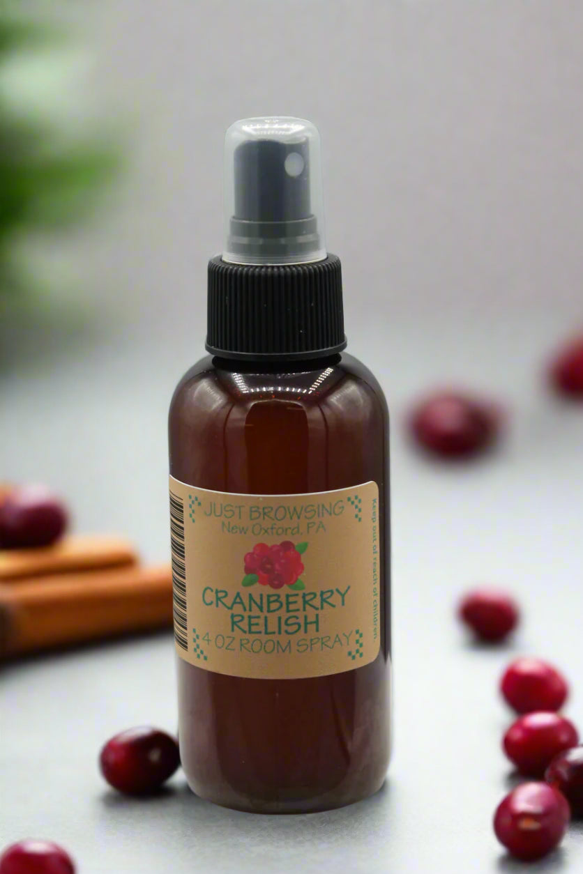Brown spray bottle with a label on a gray background with cranberries and cinnamon sticks
